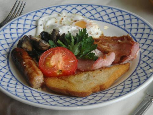 a blue and white plate of food with eggs sausage and toast at Beggars Reach Hotel in Pembroke Dock