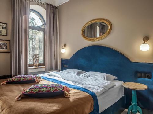 a bedroom with a large bed with a blue headboard at Greenwich by Friends in Saint Petersburg