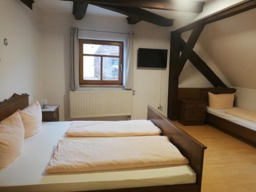 1 dormitorio con 2 camas y ventana en Gaststätte Liebl, en Wiesent