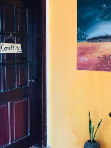 a door with a sign that reads carolina next to a plant at Chino Homestay Măng Đen - Villa tại Măng Đen in Kon Tum