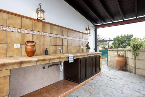 Villa Rural La Zarza by Sunkeyrents في Fasnia: مطبخ مع حوض و مزهرية على الحائط