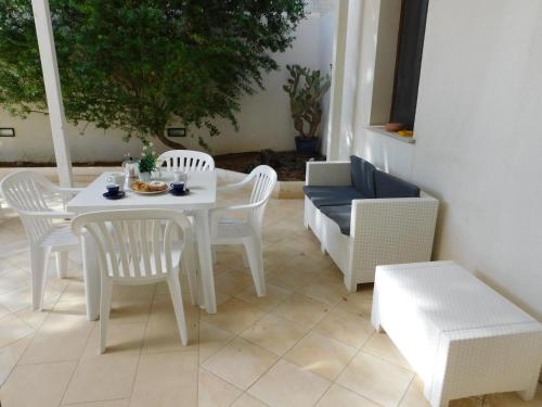 a white table and chairs on a patio at Case Vacanza Elisir in Favignana