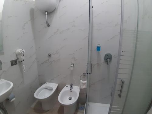 a bathroom with a toilet and a sink and a shower at Albergo Viola in Naples
