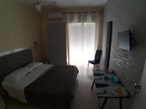 a bedroom with a bed and a window and a chair at Albergo Viola in Naples