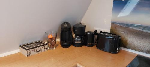 a coffee maker and a blender on a wooden floor at B&B Buiten Gewoon Callantsoog in Callantsoog