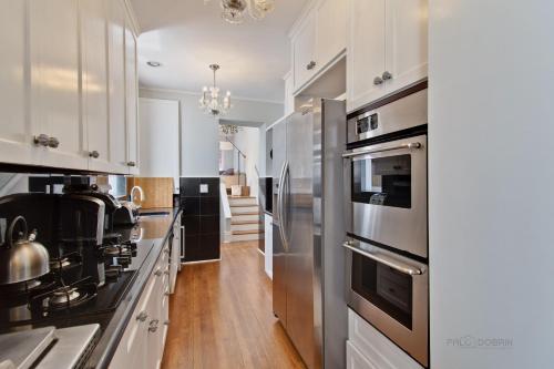 a kitchen with white cabinets and stainless steel appliances at Historic luxury Townhouse in Downtown Chicago in Chicago