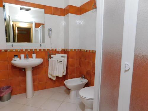 a bathroom with a sink and a toilet and a mirror at Case Vacanza Elisir in Favignana