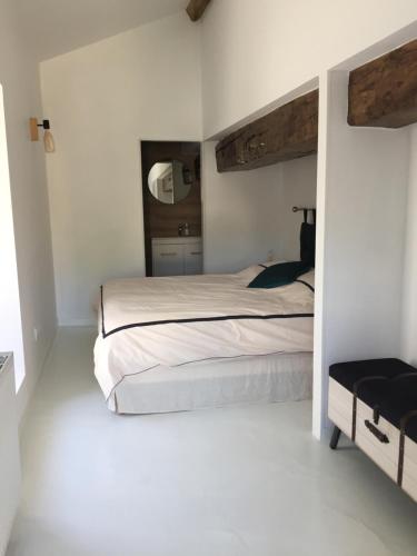 une chambre avec un grand lit et un miroir dans l'établissement La Maison BellecOur, à Vaudelnay