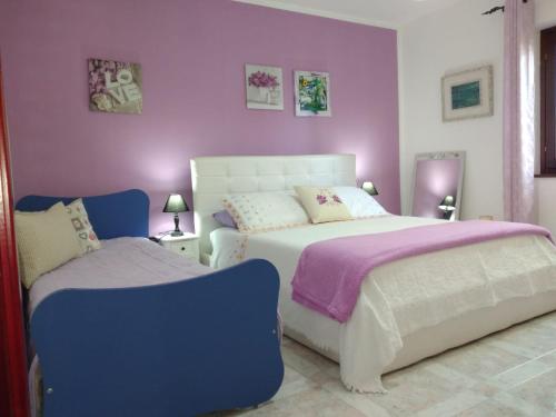 una camera con due letti e pareti viola di Sole e Luna a Oliena