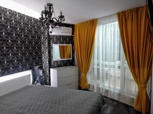 a bedroom with a bed and yellow curtains and a mirror at Valentina GOLD apartment in Plovdiv