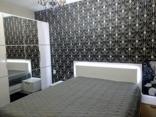 a bedroom with a bed and a black and white wallpaper at Valentina GOLD apartment in Plovdiv