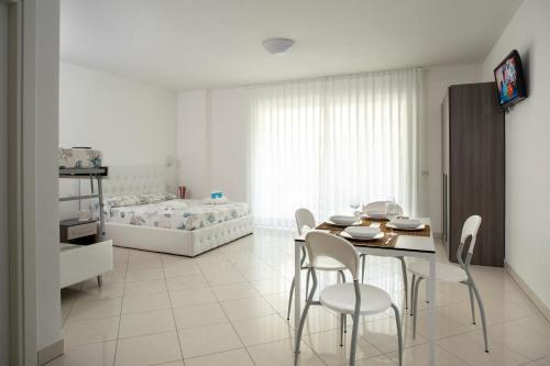 a bedroom with a table and chairs and a bed at Residence I Diamanti - Siroli Collection in Cervia