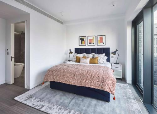 a bedroom with a large bed and a bathroom at The Eight Apartments Shoreditch in London