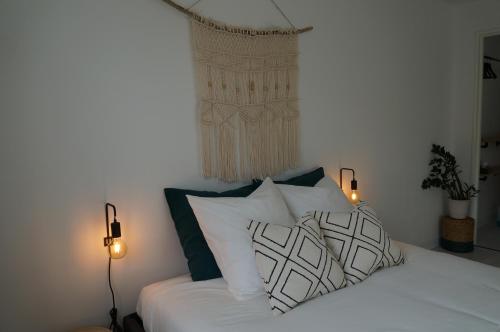 a bedroom with a bed with white sheets and pillows at Appartement Spacieux et Cosy - Strasbourg Centre in Strasbourg