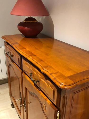 a lamp on top of a wooden cabinet with a table at LOGEMENT PERIGUEUX in Champcevinel