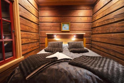 um quarto com uma cama num chalé de madeira em Taigakolo, Luosto em Luosto