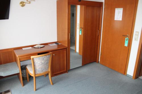 a room with a desk and a chair and a door at Landhotel Hirsch in Sankt Johann