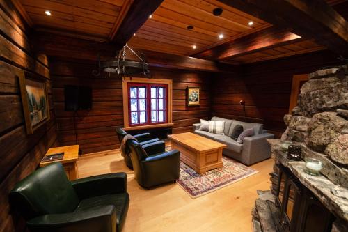 a living room with a couch and chairs in a cabin at Taigakolo, Luosto in Luosto