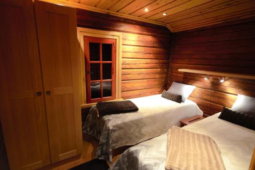 1 Schlafzimmer mit 2 Betten und einem Fenster in der Unterkunft Taigakolo, Luosto in Luosto