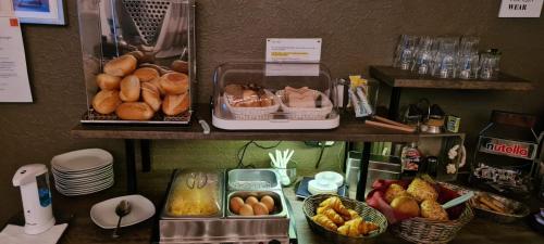 a counter with bowls of bread and baskets of fruit at Hotel Reuter in Haiger