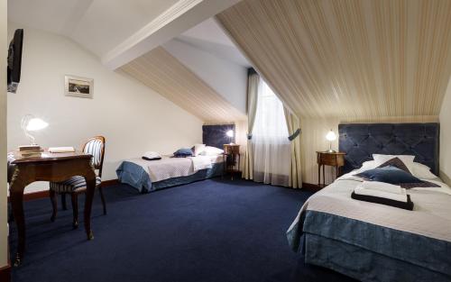 sypialnia z 2 łóżkami i biurkiem na poddaszu w obiekcie Hotel Stary Zdrój w Świeradowie Zdroju