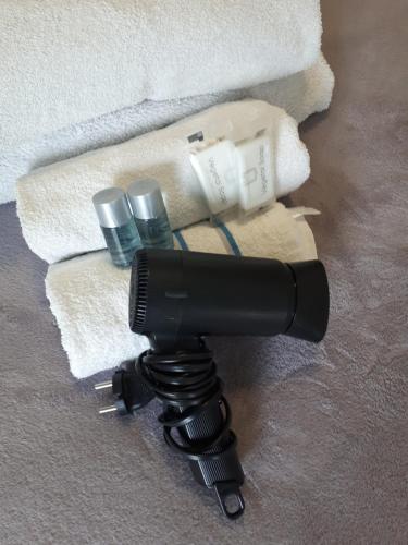 a hair dryer on a tripod next to towels at Apartment Bruneck Central in Brunico