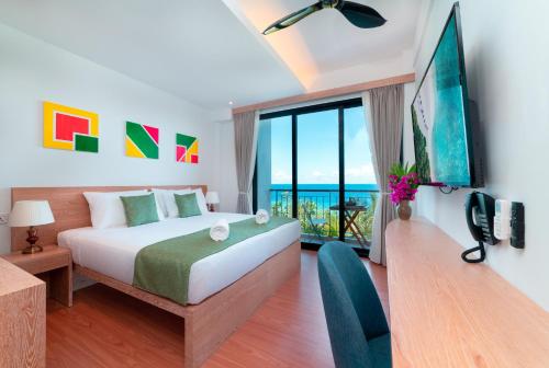 a bedroom with a bed and a large window at Ranthari Hotel and Spa Ukulhas Maldives in Ukulhas