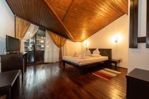 a bedroom with a bed and a television in a room at Casa Frent in Predeal
