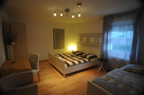 1 dormitorio con 1 cama, 1 silla y 1 ventana en Freiburg Apartment en Freiburg im Breisgau