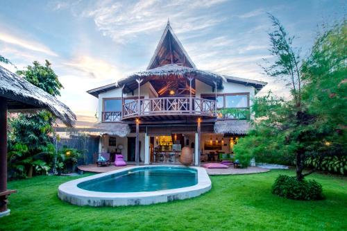 a house with a swimming pool in the yard at Breezy Point Villas in Nusa Dua