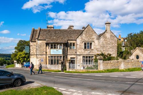 an old stone building on the corner of a street at Amberley Inn in Stroud