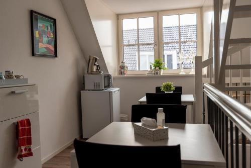 a room with a table and chairs and windows at Dinie's Bed en Brood in 's-Heerenbroek