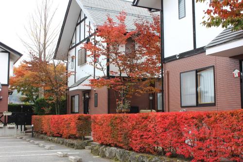 a house with red bushes in front of it at Ururun Kawaguchiko in Fujikawaguchiko