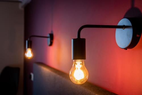 a couple of lights on a wall with a mirror at De Drie Linden in Luyksgestel