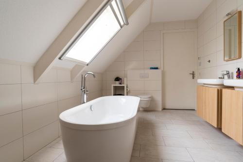 La salle de bains est pourvue d'une baignoire et d'une fenêtre. dans l'établissement Dinie's Bed en Brood, à 's-Heerenbroek