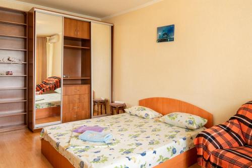 een kleine slaapkamer met een bed en een spiegel bij Квартира по адресу Приозерная 8 Б Оболонь in Kiev
