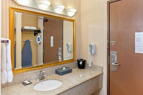 a bathroom with a sink, mirror, and toilet at La Quinta by Wyndham Stevens Point in Stevens Point