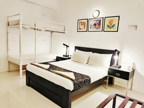 a bedroom with a bed and a bunk bed at Bedrock Boutique Hostel in Baga