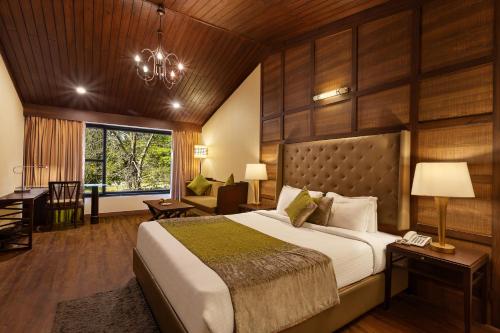 a bedroom with a large bed and a desk at The Earls Court by Leisure Hotels in Nainital