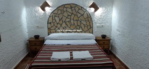 a bedroom with a bed with two white pillows at Cuevas Lourdes in Benamaurel