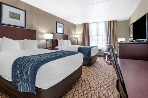 a hotel room with two beds and a flat screen tv at Comfort Inn & Suites Glen Mills - Concordville in Glen Mills
