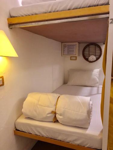 a bedroom with two bunk beds and a lamp at Bedrock Boutique Hostel in Baga