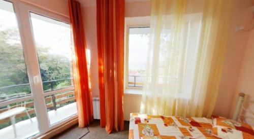 a bedroom with a bed and a large window at Guest House Villa Nadezhda in Lazarevskoye
