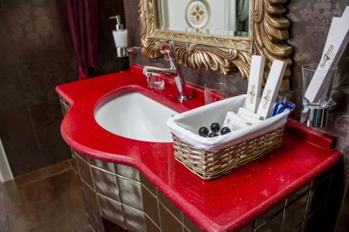 a bathroom sink with a toothbrush holder and soap dispenser at Boutique Spa Casino Hotel Lybid Plaza in Khmelnytskyi