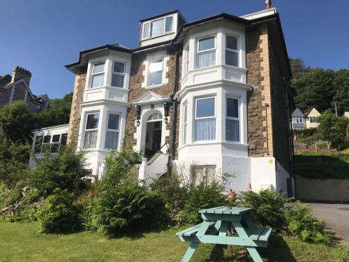 una casa con una mesa de picnic delante de ella en Cairn House en Ilfracombe