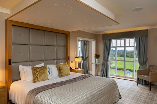 A bed or beds in a room at Carden Park Hotel, Golf Resort and Spa