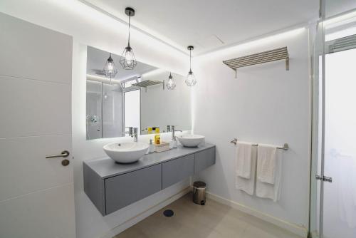 a white bathroom with two sinks and a mirror at Villa Carlota Costa Adeje in Adeje