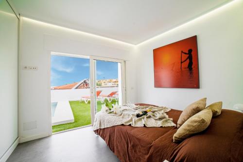 a bedroom with a bed and a large window at Villa Carlota Costa Adeje in Adeje