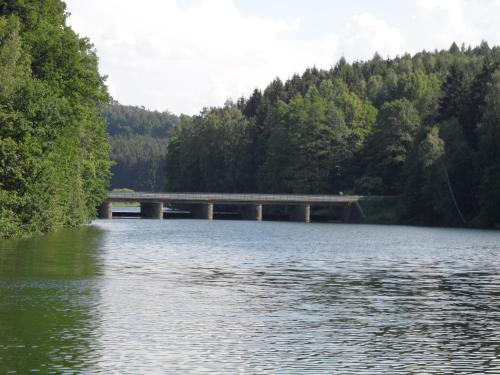 a bridge over a body of water with trees at Am Brunnen Merkendorf in Zeulenroda