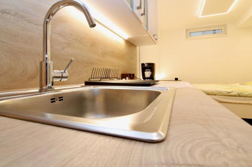 um lavatório de aço inoxidável numa cozinha com uma cama em Central STUDIO WORK and TRAVEL em Viena